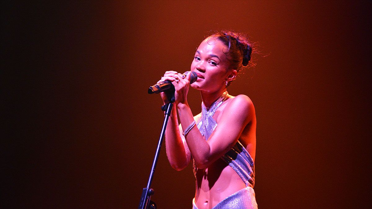 Imagem de mulher vista lateralmente segurando um microfone