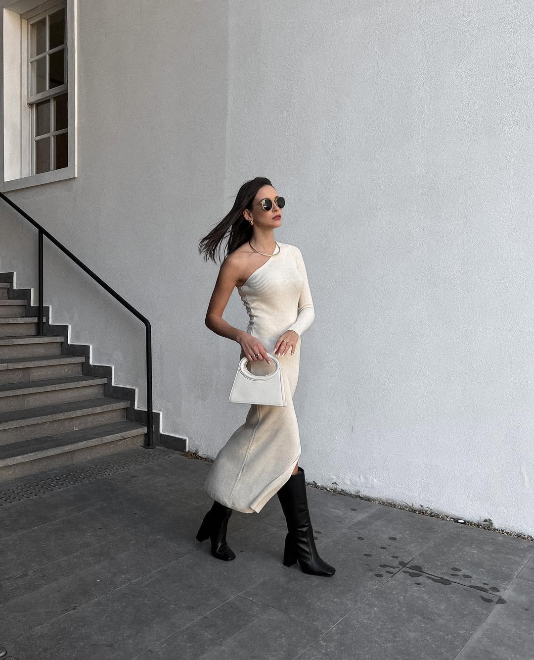 Combinar vestido longo branco com bota de cano preto est&aacute; em alta e forma look elegante