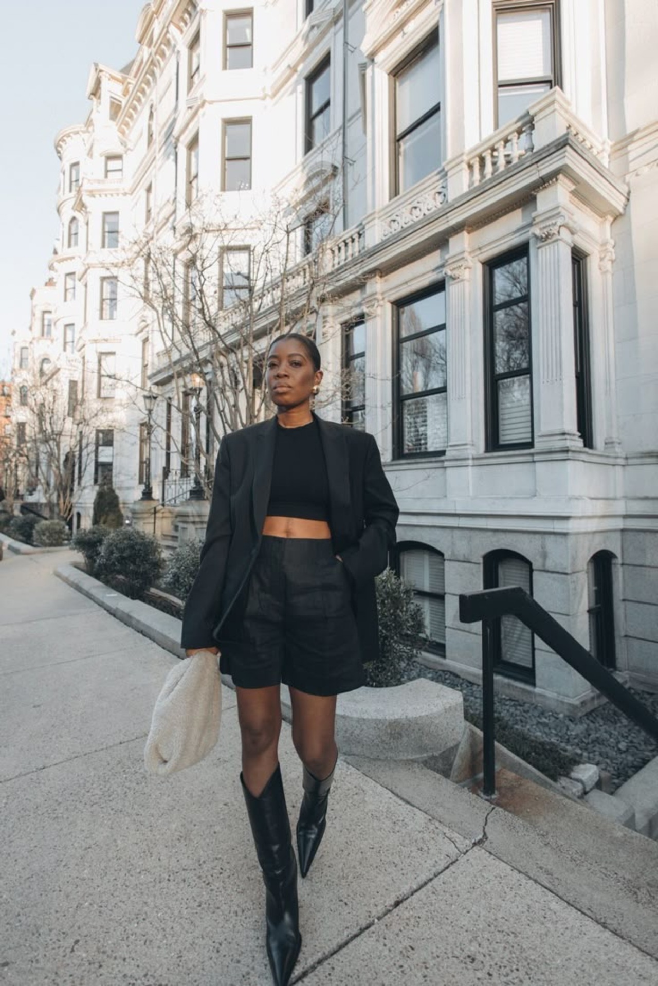 Proposta all black com shorts e botas de bico fino.