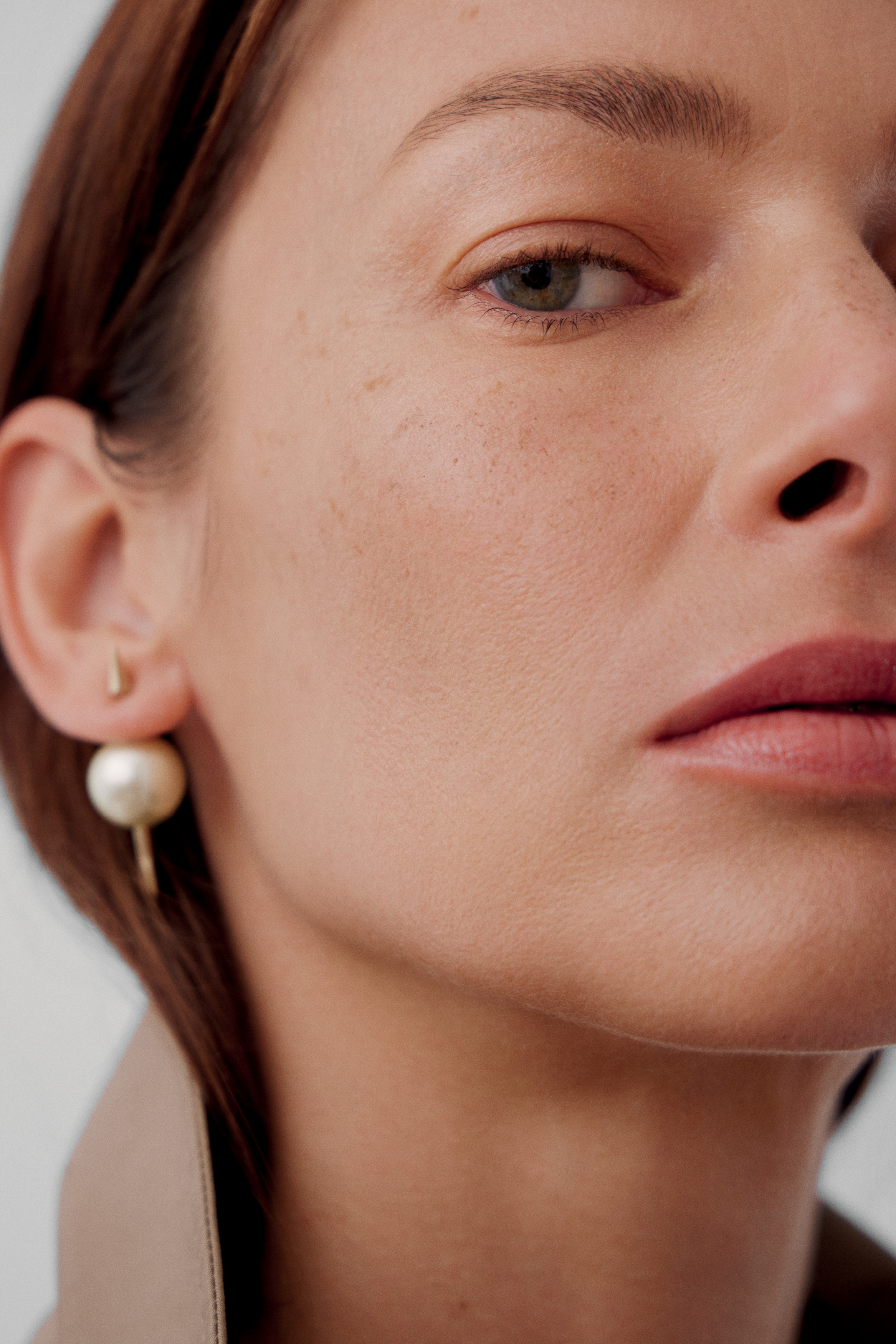 Imagem de mulher branca exibindo maquiagem delicada e feminina. O fundo &eacute; preto e ela usa uma regata de manga &uacute;nica.