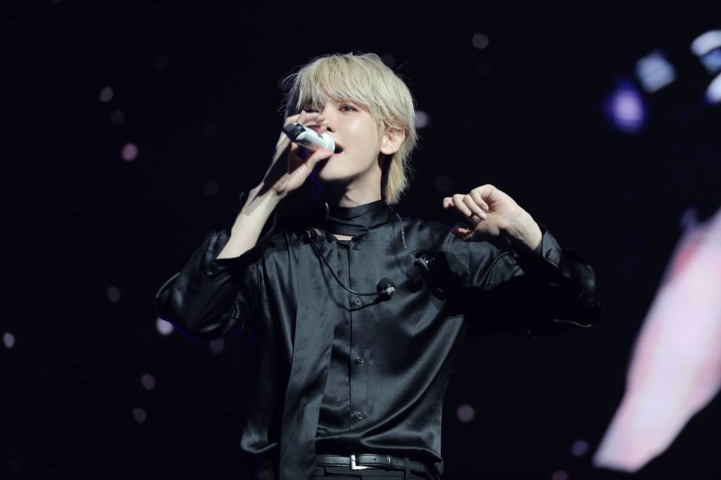 Baekhyun com mic na mão durante essa sessão da tour Reverie no Brasil.