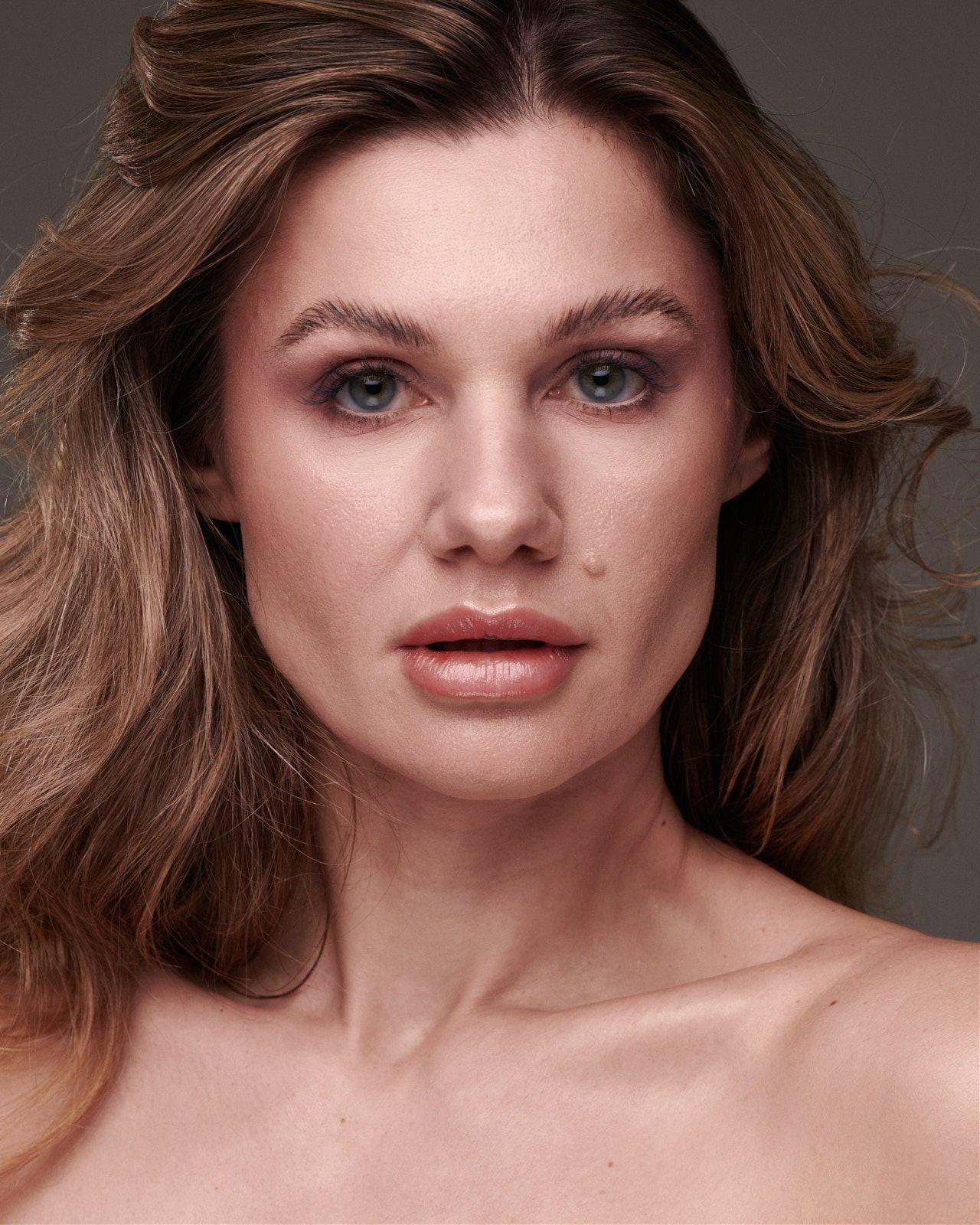 Imagem mostra mulher loira com maquiagem neutra e sobrancelhas alinhadas.