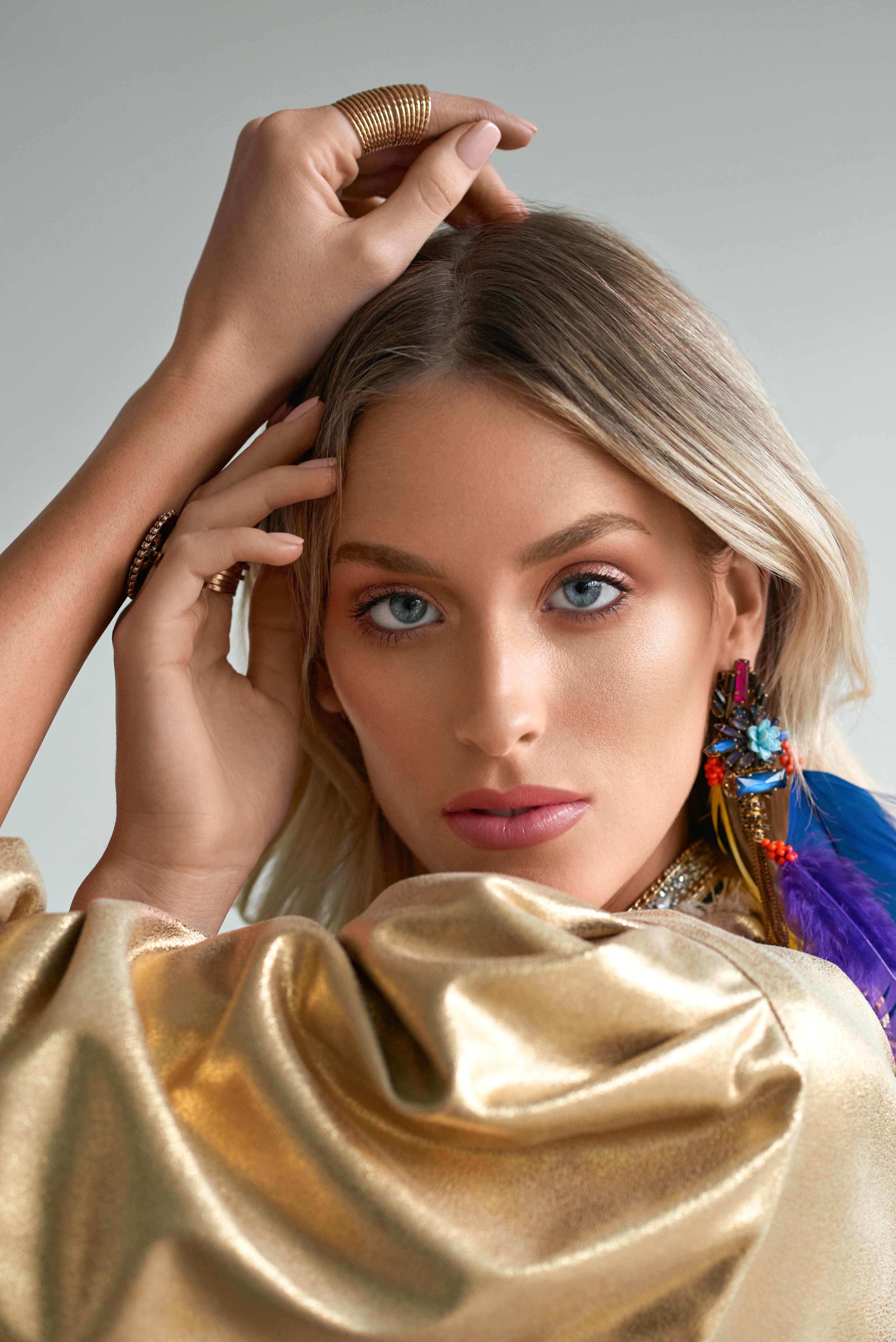 Imagem mostra mulher loira com maquiagem leve e olhos cintilantes.