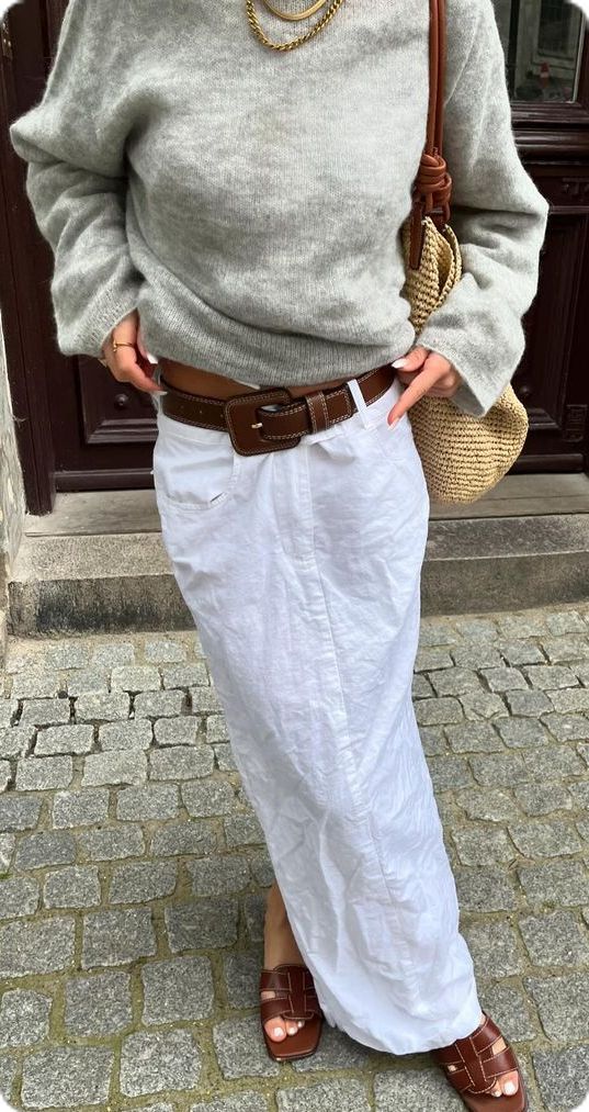 Look com su&eacute;ter cinza, saia branca e cinto marrom marcando a cintura