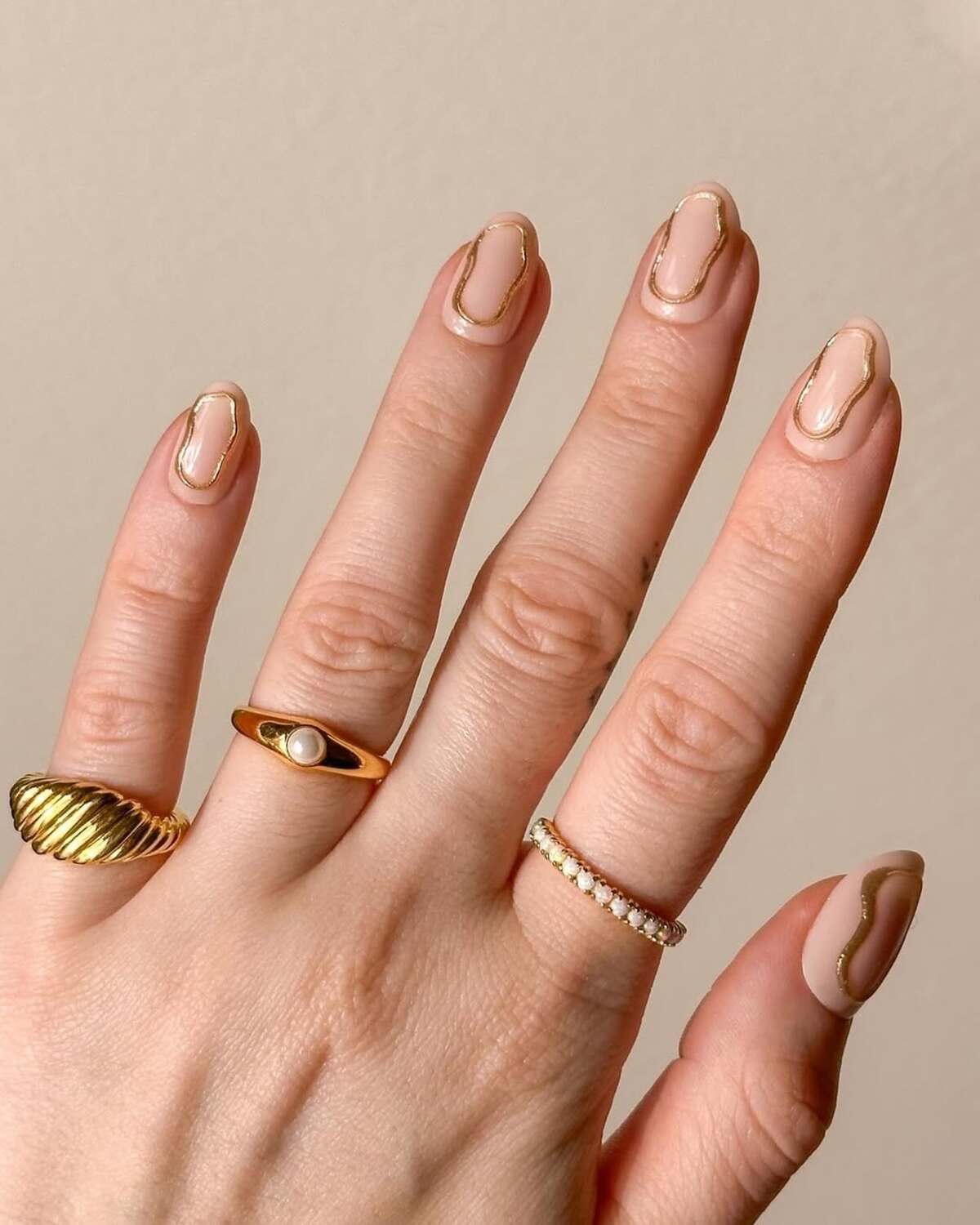 Imagem de unha amendoada curta com design metalizado.