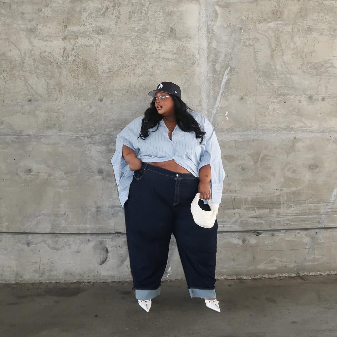 Look plus size com jeans escuro, camisa oversized e scarpin branco