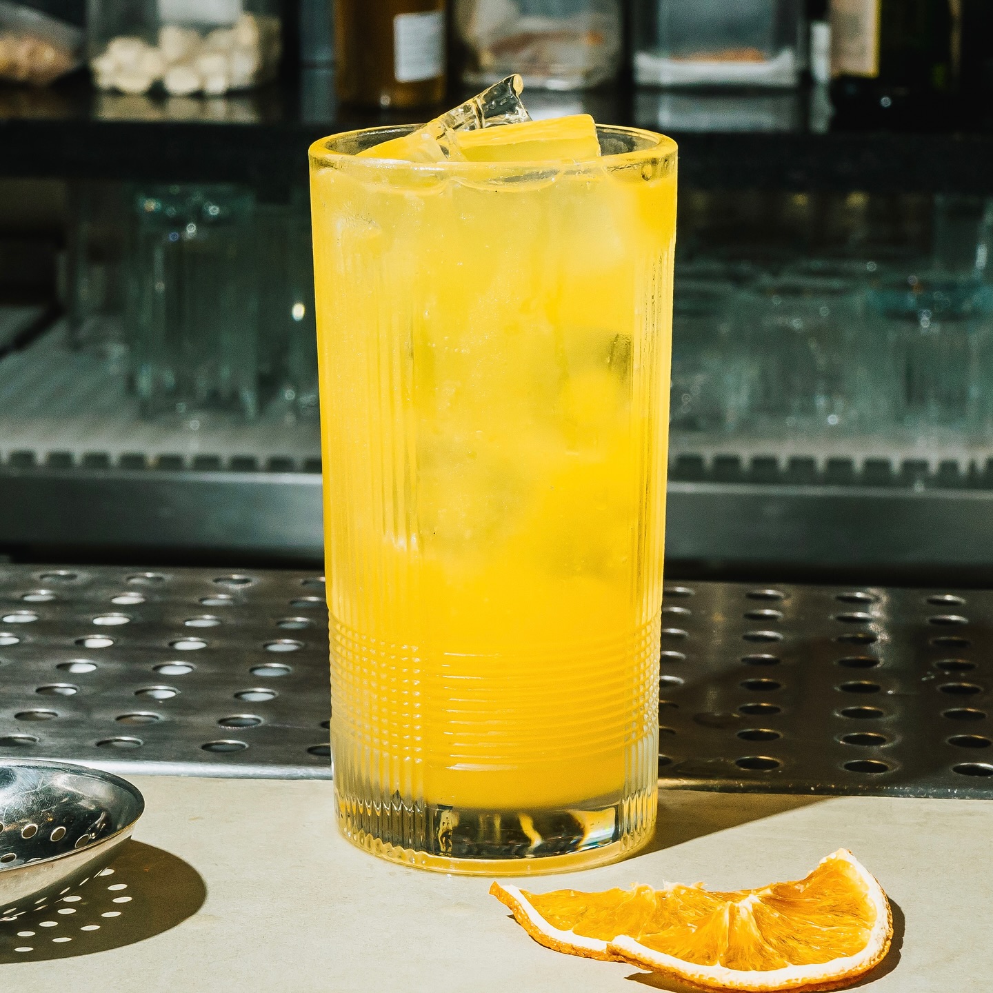 Imagem de copo de drink ao lado de fatias de laranja