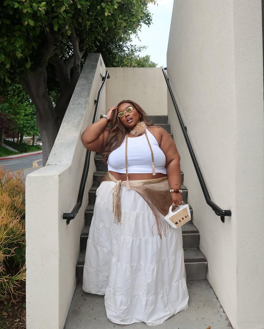 Look plus size com regata cropped e saia longa flu&iacute;da branca