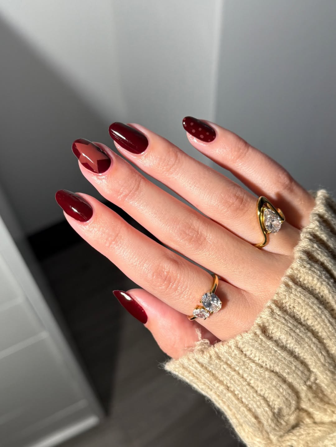 Foto de uma m&atilde;o com as unhas amendoadas e vinho