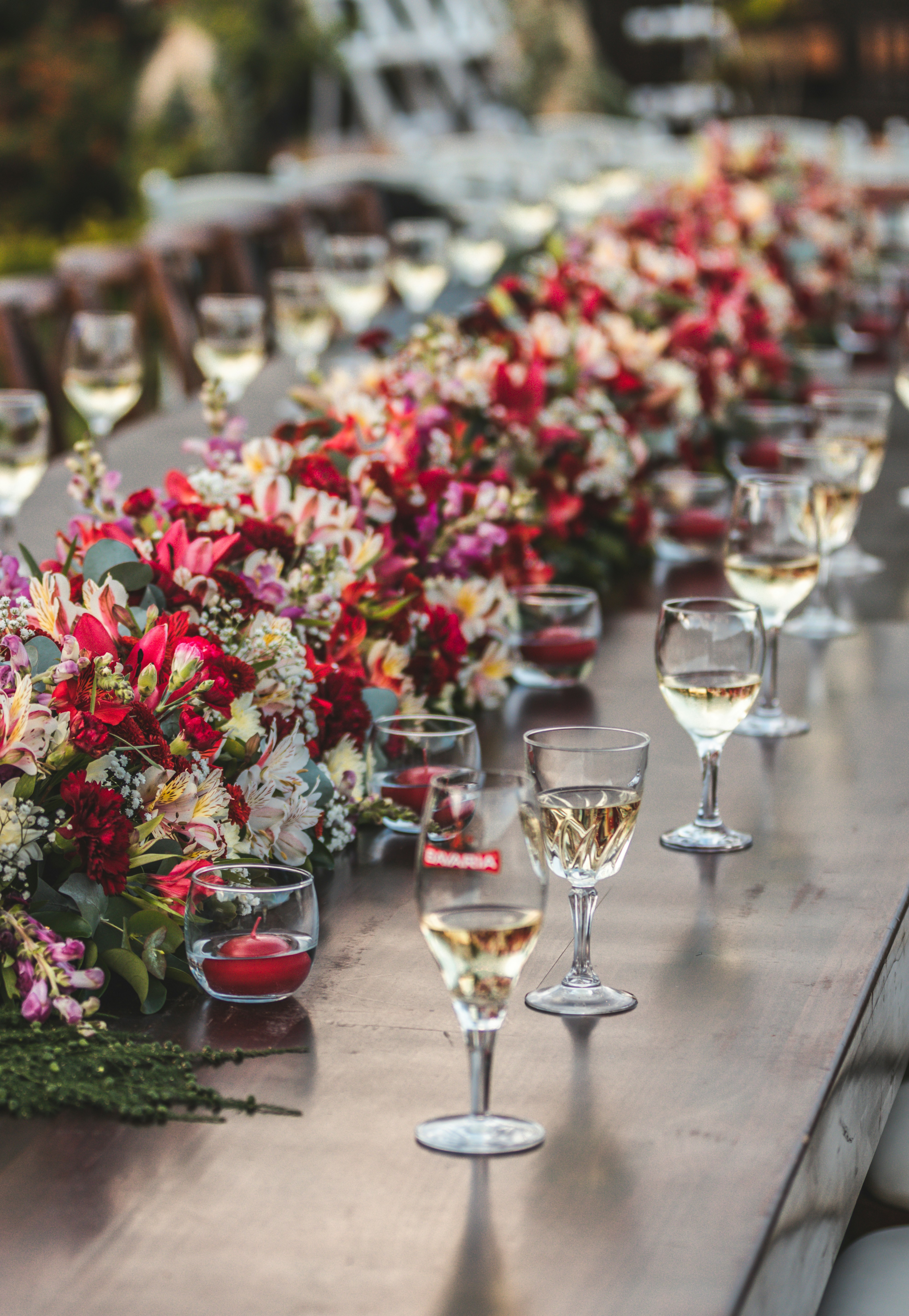 Mesa retangular de casamento decorada com vasos de rosas