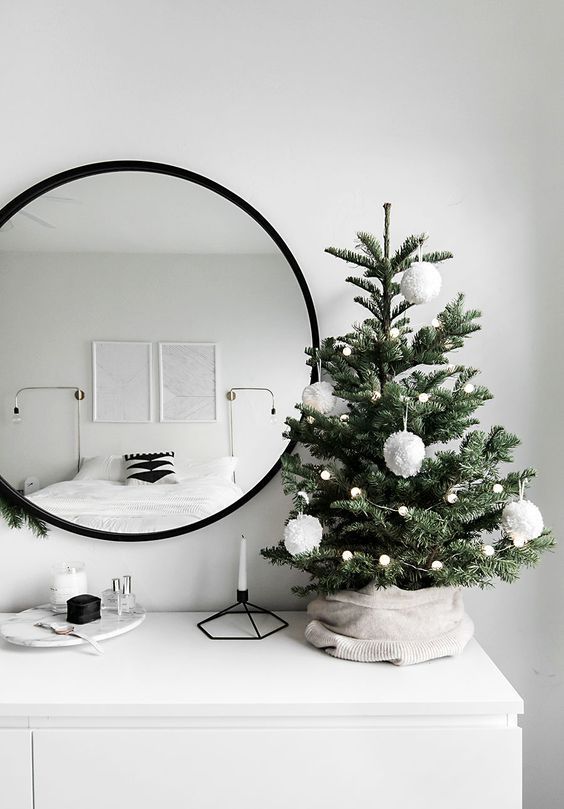 Mini &aacute;rvore de Natal decorada com bolas brancas.
