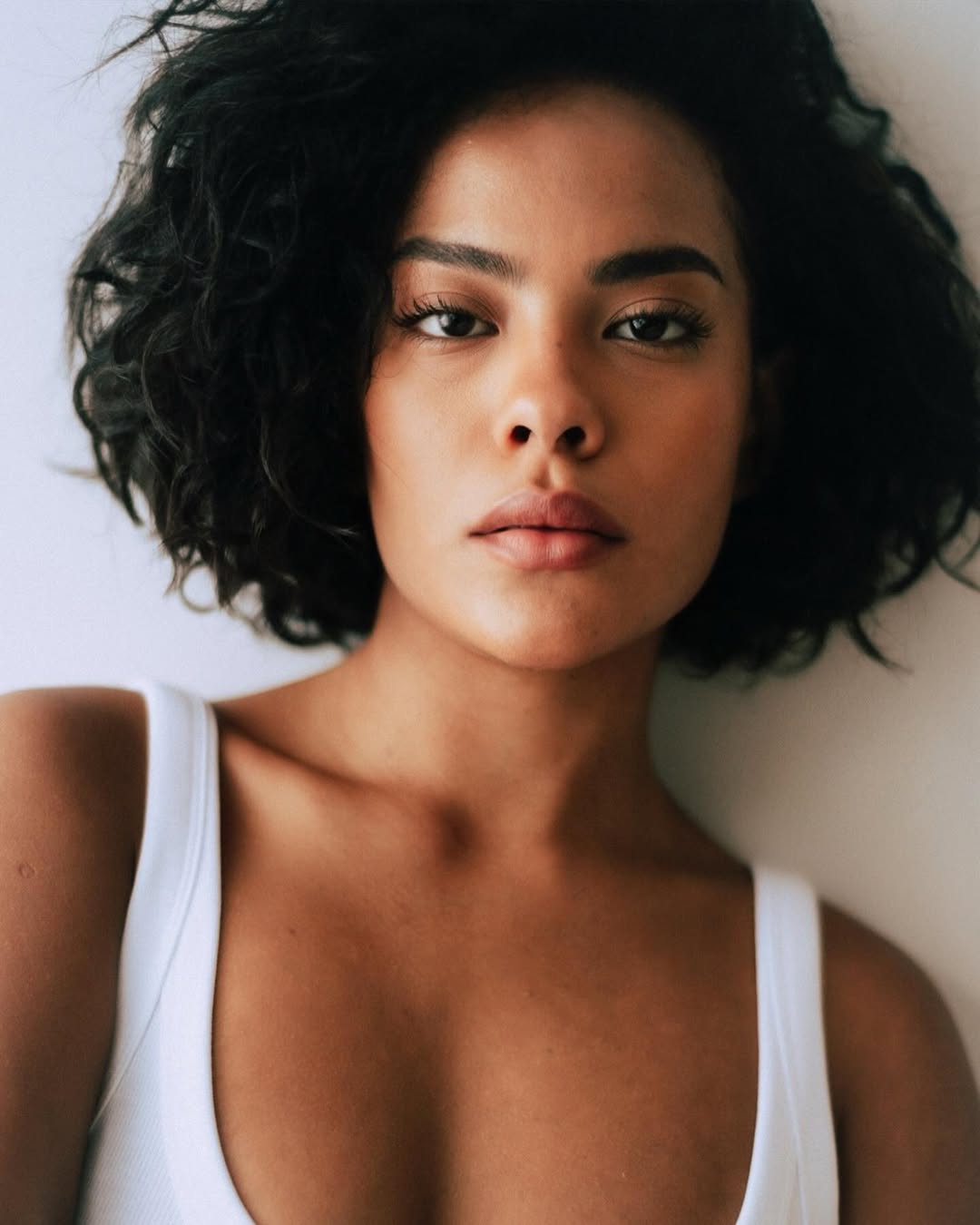 Foto de Bella Campos. Ela &eacute; negra e est&aacute; usando um cabelo com o comprimento na altura do queixo, cacheado e volumoso