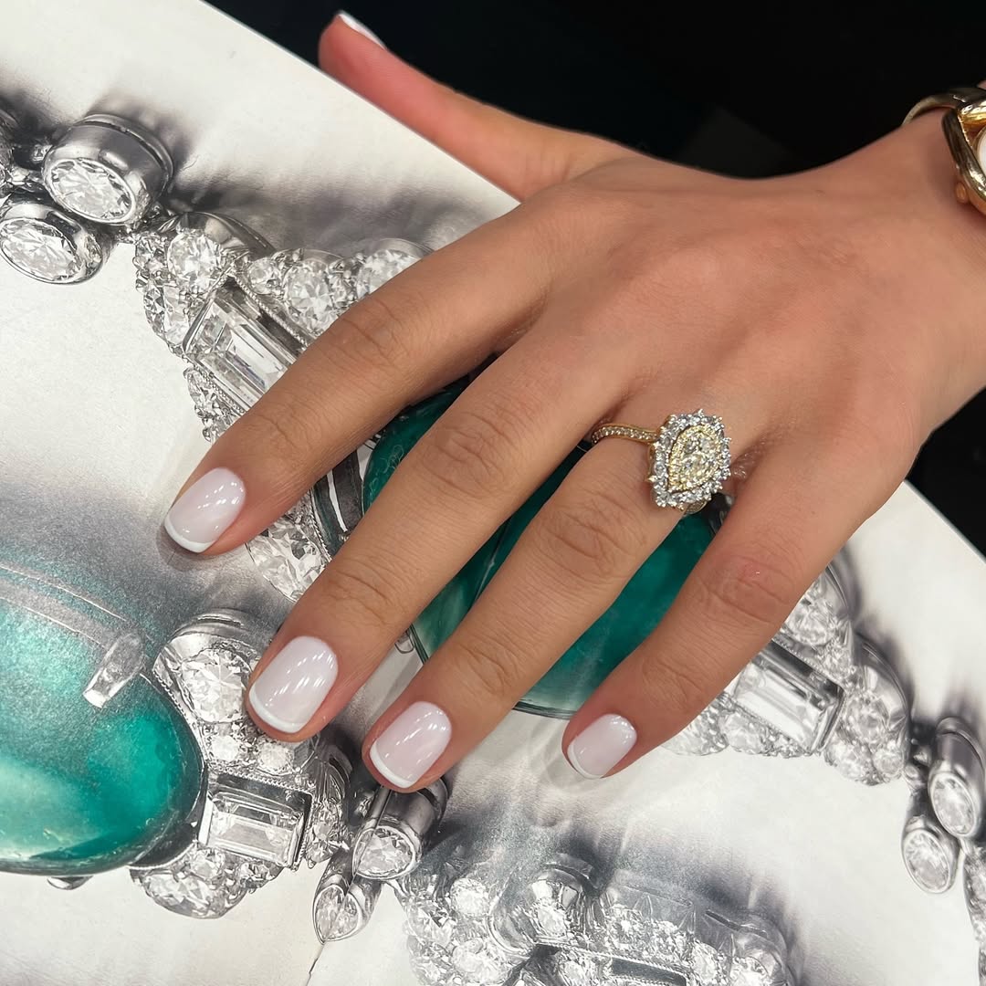 Foto de uma m&atilde;o com as unhas coloridas de branco e com francesinhas brancas