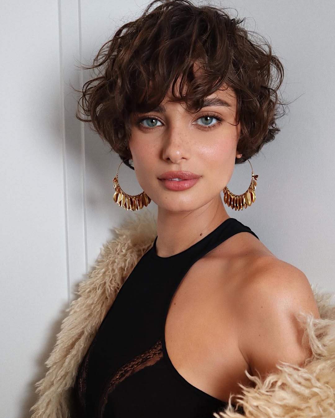 Foto de uma mulher branca com o cabelo cortado pixie ondulado