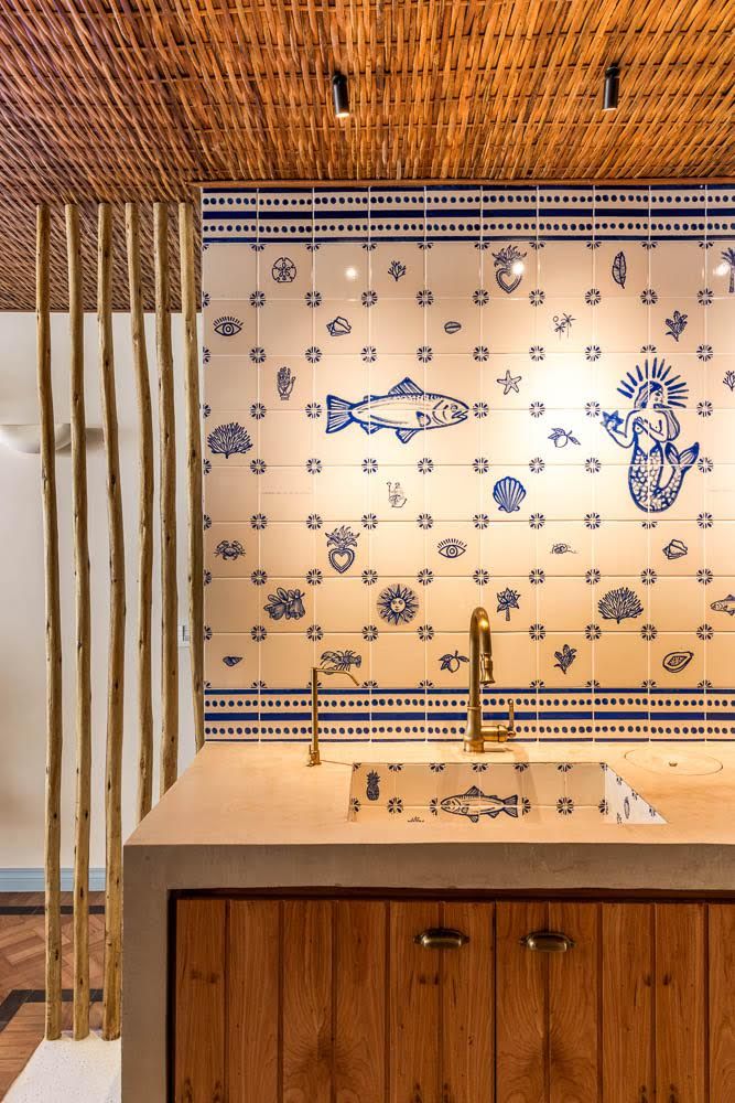 Integrada &agrave; bancada clara, ela traz uma padronagem azul sobre fundo branco que dialoga diretamente com o painel de azulejos ao fundo
