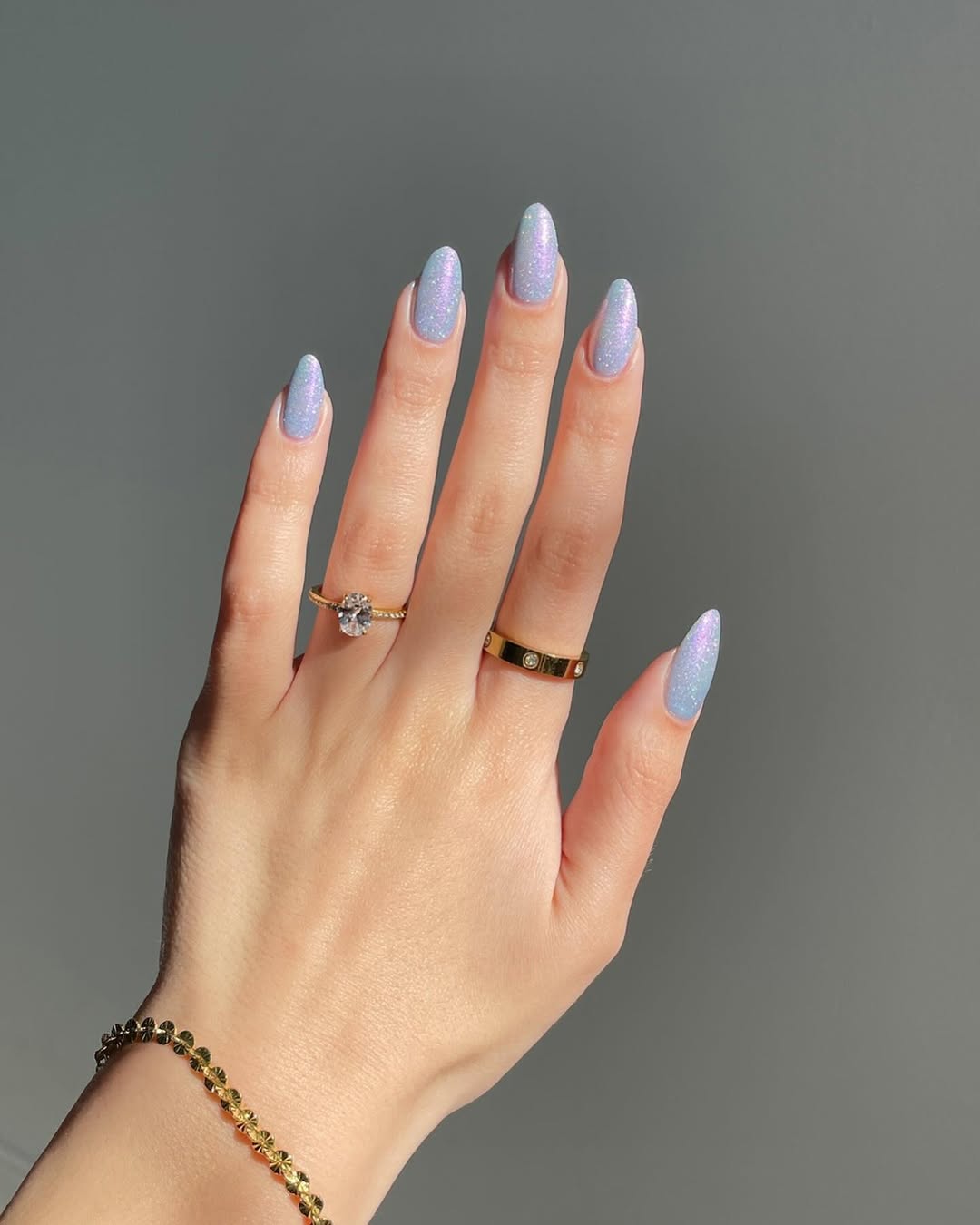 Foto de uma m&atilde;o com unhas coloridas de lil&aacute;s