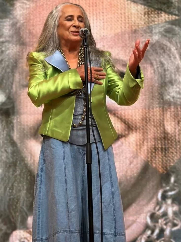 Cantora de vestido azul e brazer verde
